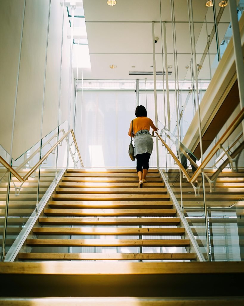 Woman walking up brown stairs